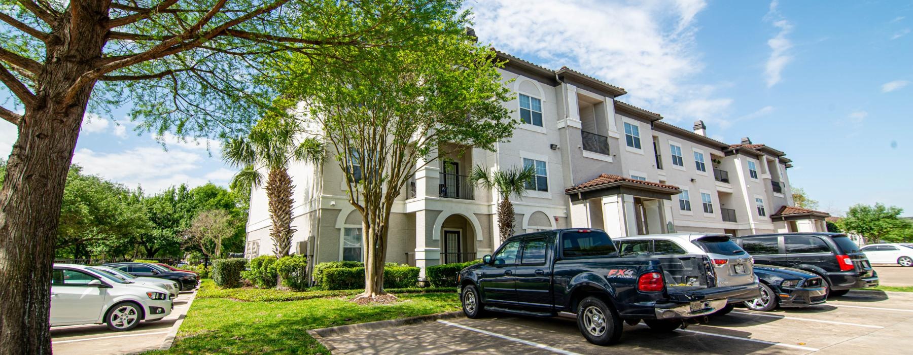 a row of cars parked in front of a white building
