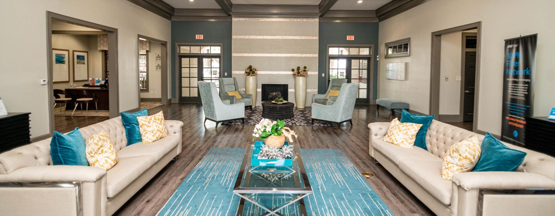 a living room with a blue rug and white couches