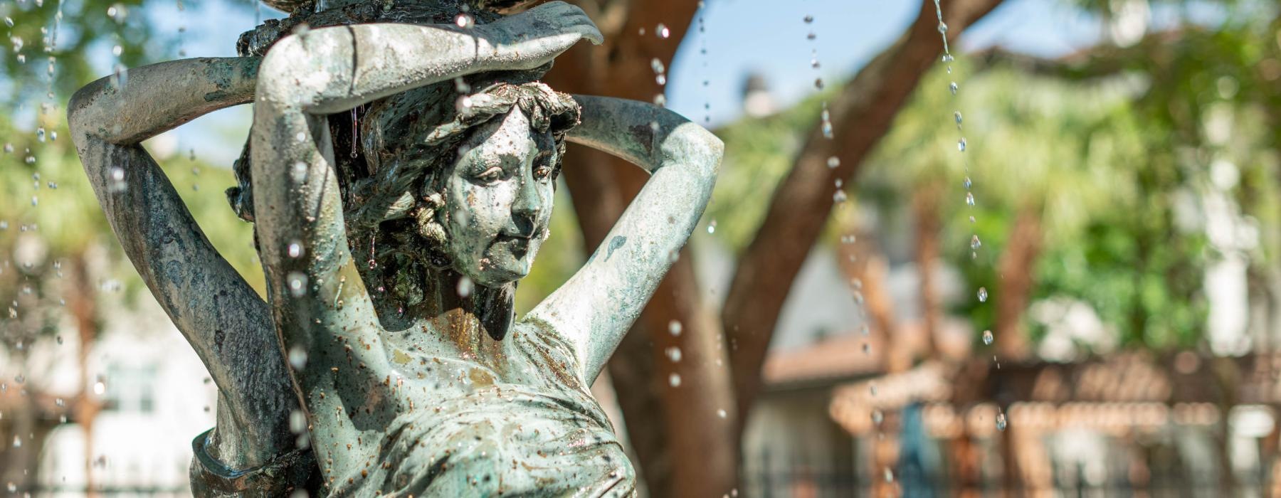 a statue of a person holding a water fountain